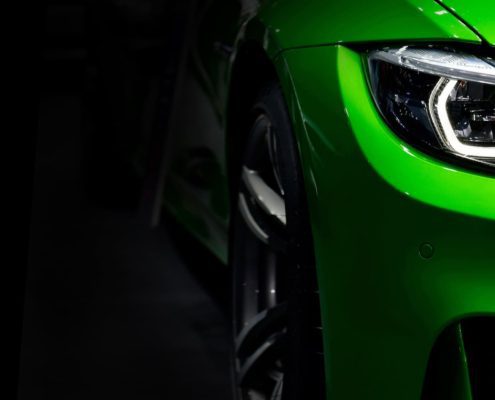front-headlights-green-modern-sport-car-black-background